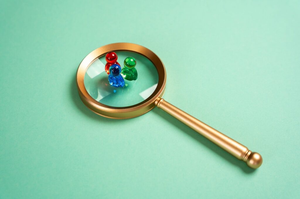 Figures of people and a magnifying glass. Search for recruitment. Social research.