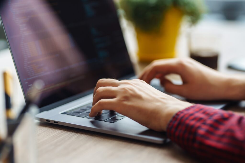 Close up picture of male hands working on her laptop. Social networking technology concept.